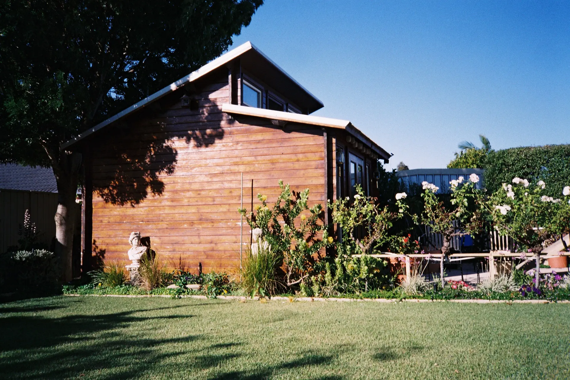 Small wood-sided backyard cottage on a lawn