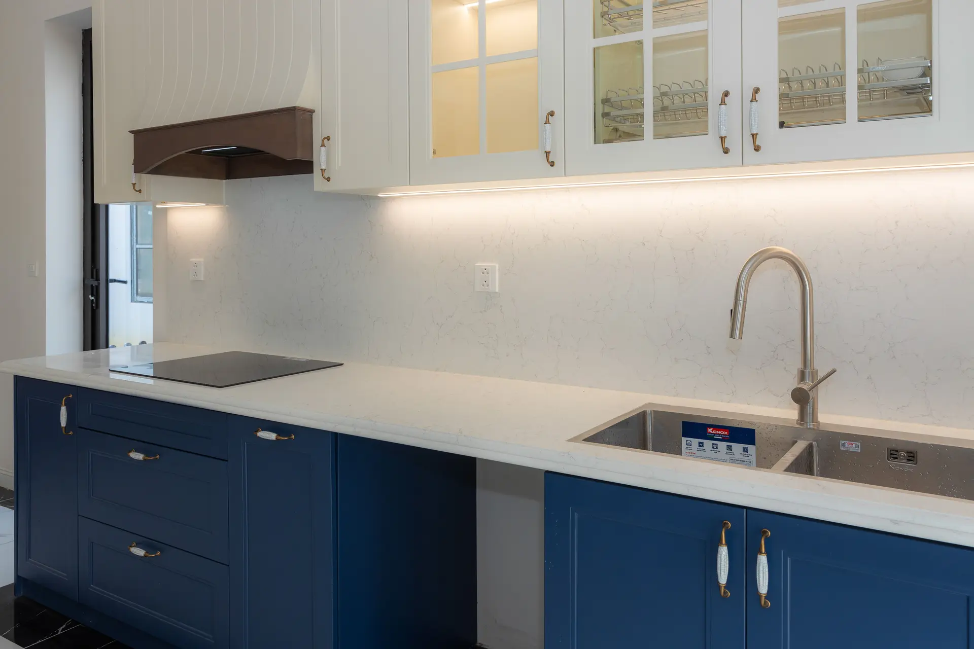 Kitchen with navy lower cabinets and white quartz counters