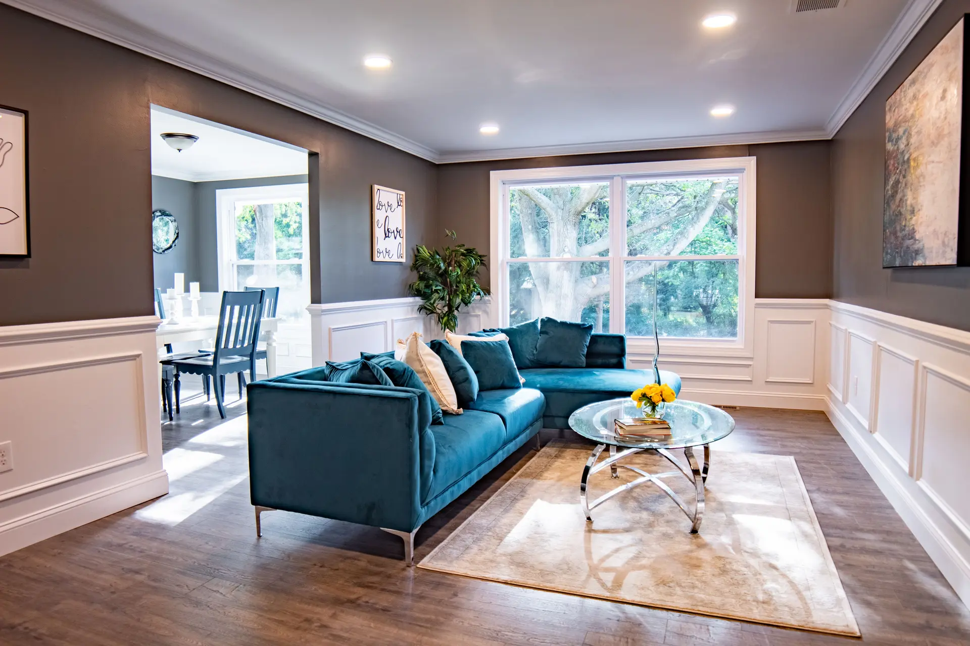 Renovated living room with white wainscoting and a blue sofa