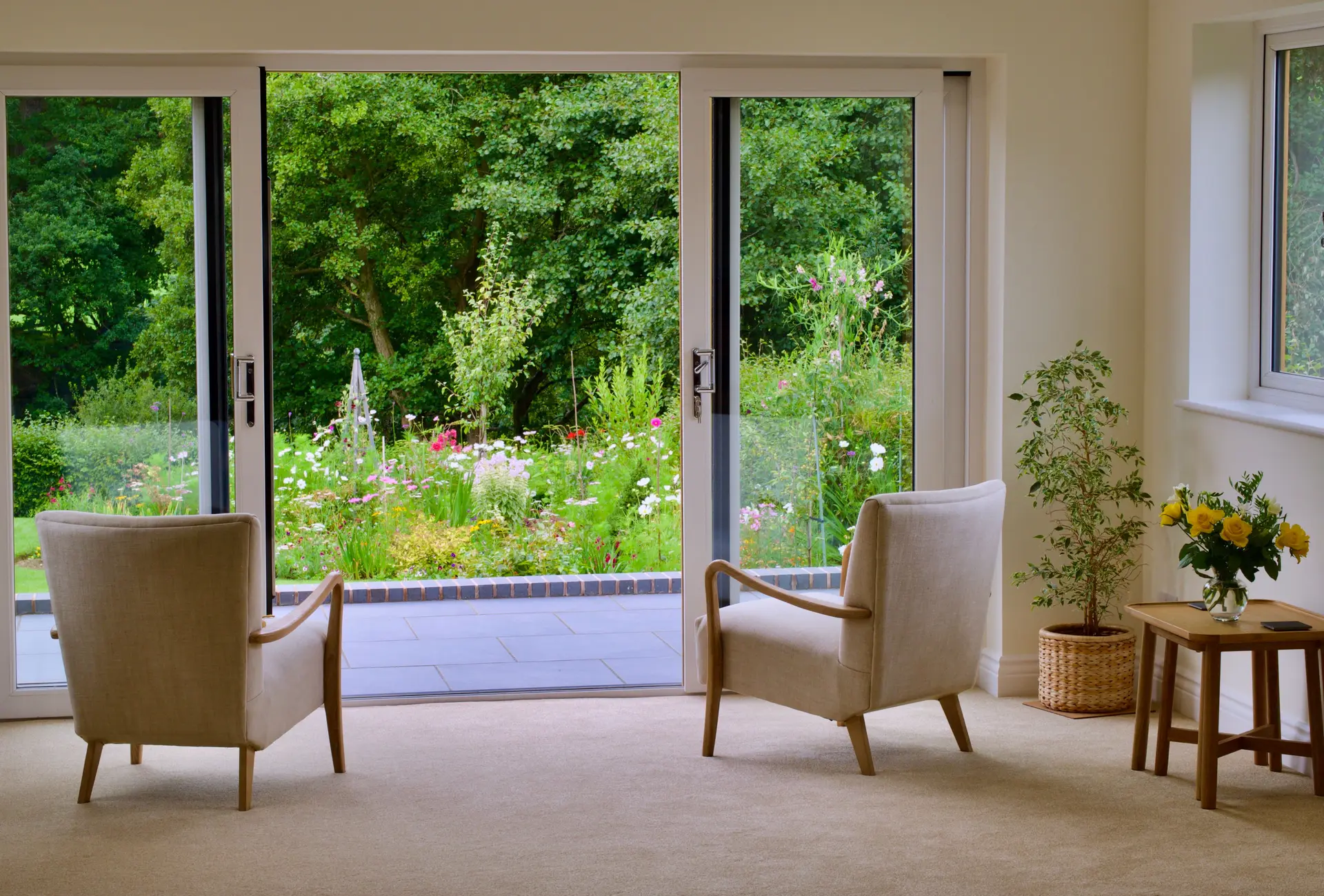 Sliding glass doors opening from a bright room onto a garden